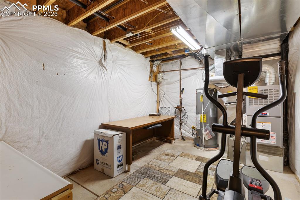Image 26 of 36: Unfinished below grade area featuring gas water heater and heating unit