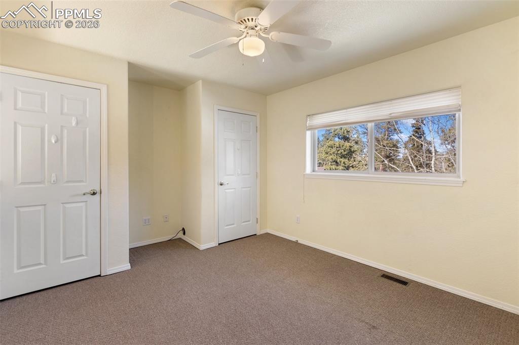Image 29 of 36: Unfurnished bedroom with carpet flooring and ceiling fan