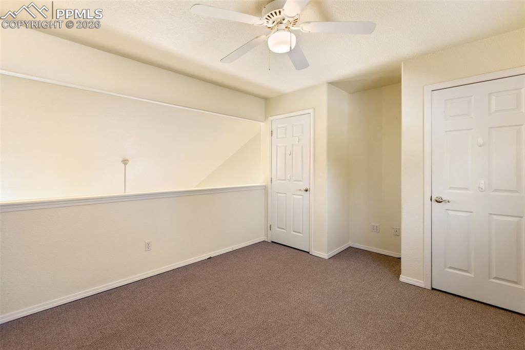Image 30 of 36: Spare room with ceiling fan and carpet floors