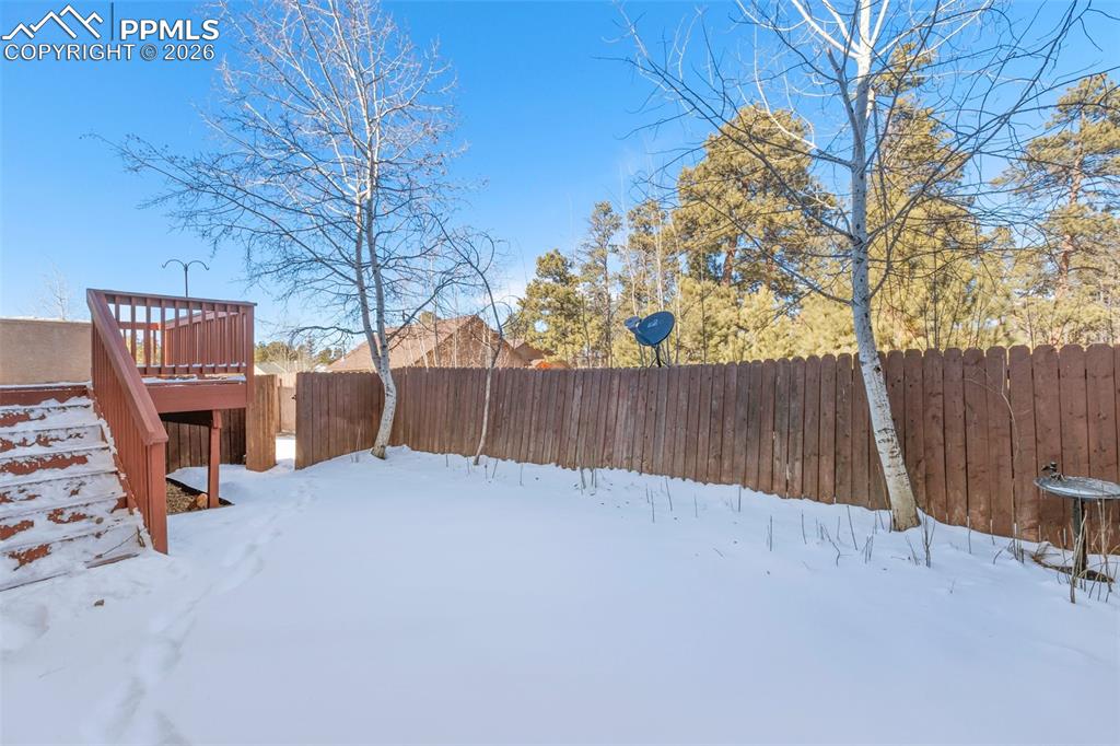 Image 34 of 36: Yard covered in snow featuring a fenced backyard and a deck