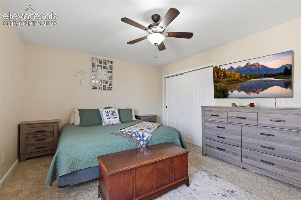 Image 14 of 28: Bedroom featuring neutral wall paint, carpet flooring, a ceiling fan with i