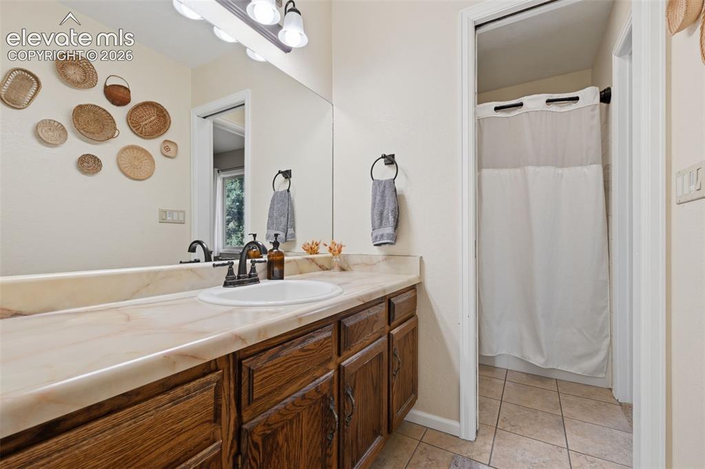 Image 16 of 28: Bathroom vanity featuring a single basin, bronze-finish faucet, and substan