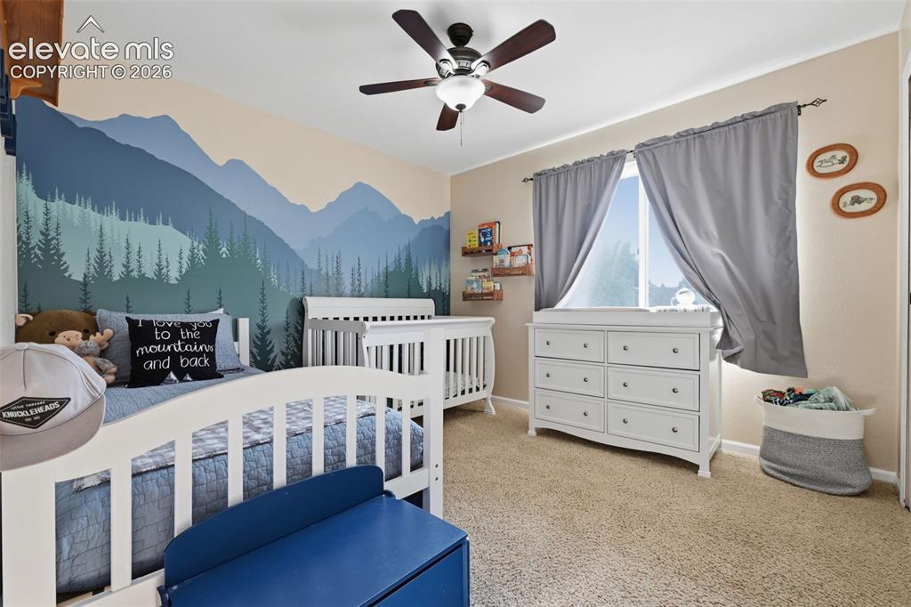 Image 19 of 28: Spacious room featuring neutral carpeting, a dual-pane window with drapery,