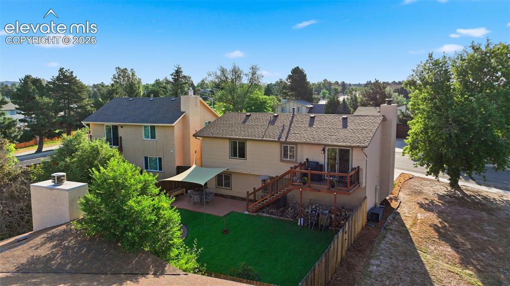 Image 26 of 28: Rear exterior featuring a multi-level deck with wooden railing and stairs,