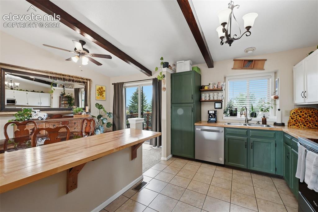 Image 6 of 28: Kitchen featuring exposed ceiling beams, a wood-finish countertop island, t