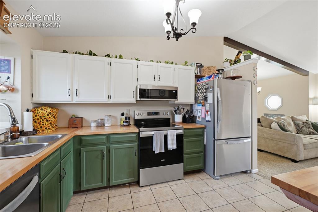 Image 7 of 28: Kitchen featuring two-tone cabinetry with white upper and green lower cabin