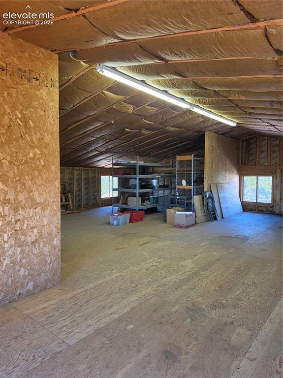 Image 36 of 38: Expansive open space featuring plywood walls and flooring