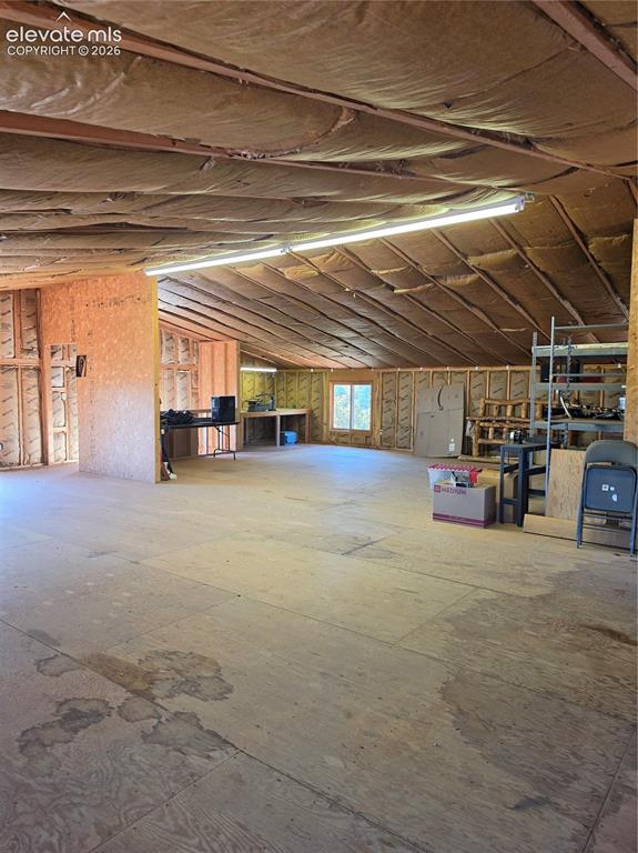 Image 37 of 38: Open-concept interior with plywood flooring and framed walls