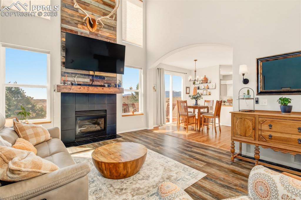 Image 17 of 45: Living room with gas burning fireplace, custom mantle, a wall of windows fo