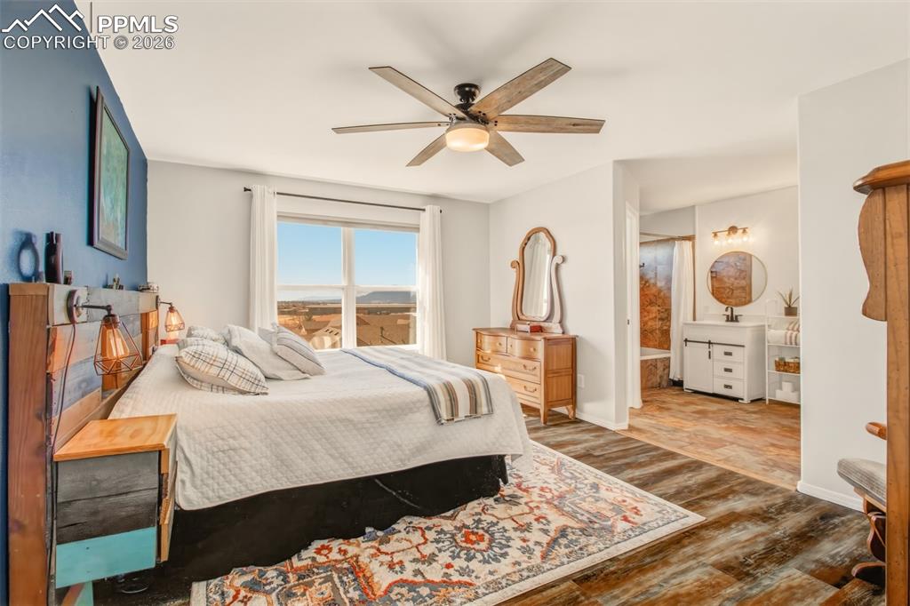 Image 21 of 45: Primary bedroom with views of the mountains out of the windows, an en suite