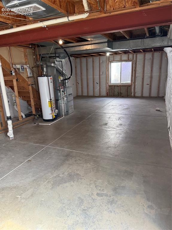 Image 18 of 21: Unfinished basement with concrete flooring and exposed ceiling joists