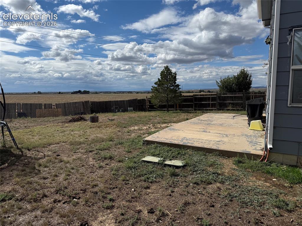 Image 21 of 21: Expansive outdoor space featuring a concrete patio and perimeter fencing