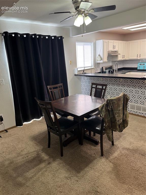 Image 4 of 21: Kitchen with white shaker-style cabinetry, subway tile backsplash, and dark
