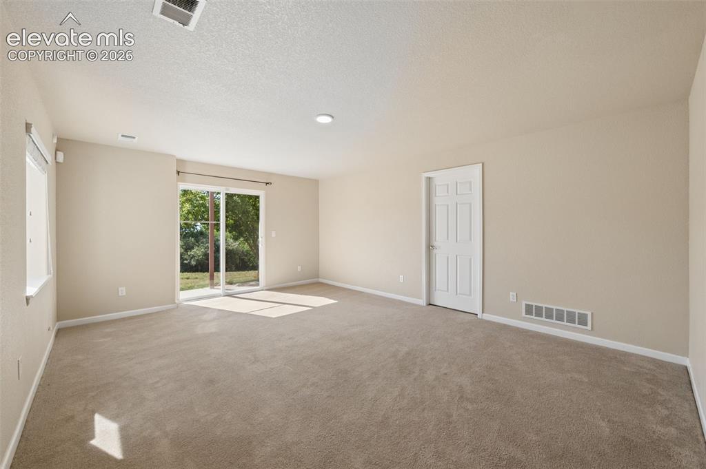 Image 25 of 37: Flex Space in basement with walkout. Door to unfinished portion of basement