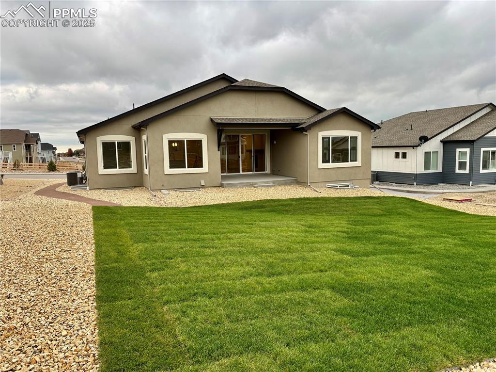 Image 30 of 31: Back of property with a patio area, stucco siding, and a yard