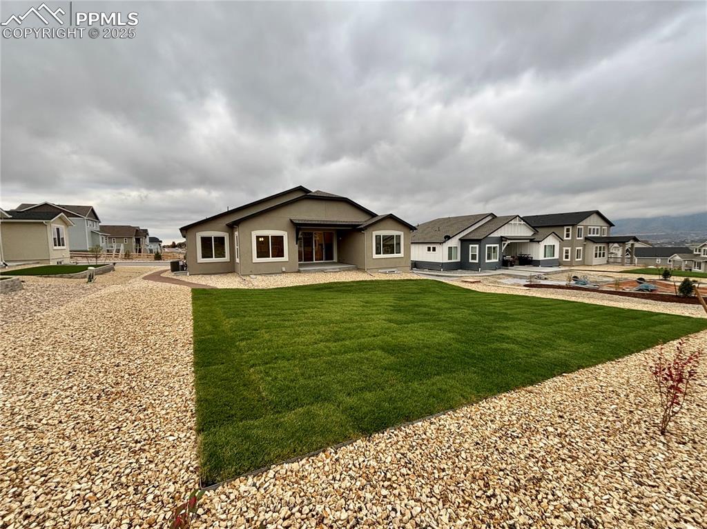 Image 31 of 31: Back of house with a residential view, a lawn, and a patio area
