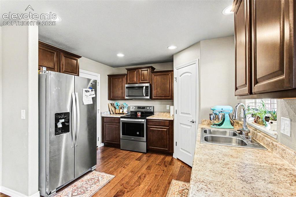 Image 12 of 27: Kitchen and dining area featuring wood-finish flooring, recessed lighting,
