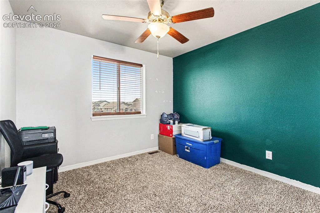 Image 18 of 27: Spacious room featuring wood-finish flooring and a ceiling fan with integra