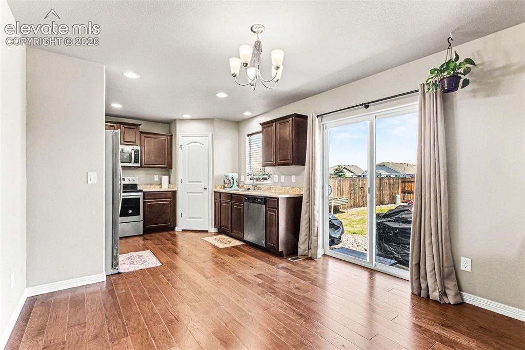 Image 8 of 27: Open-concept living area featuring a ceiling fan, a large window with blind