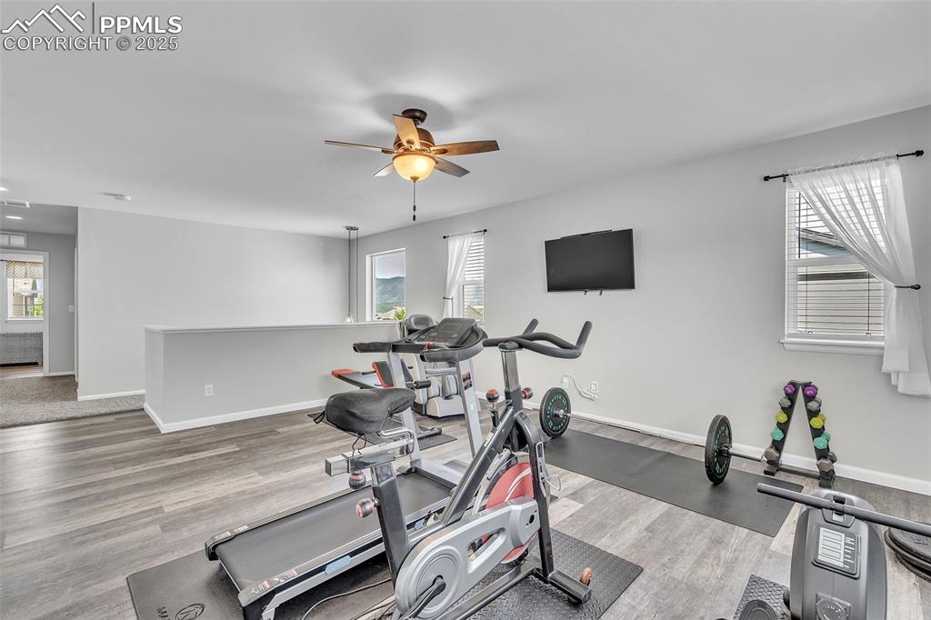 Image 15 of 50: Exercise area featuring light wood-style flooring and a ceiling fan