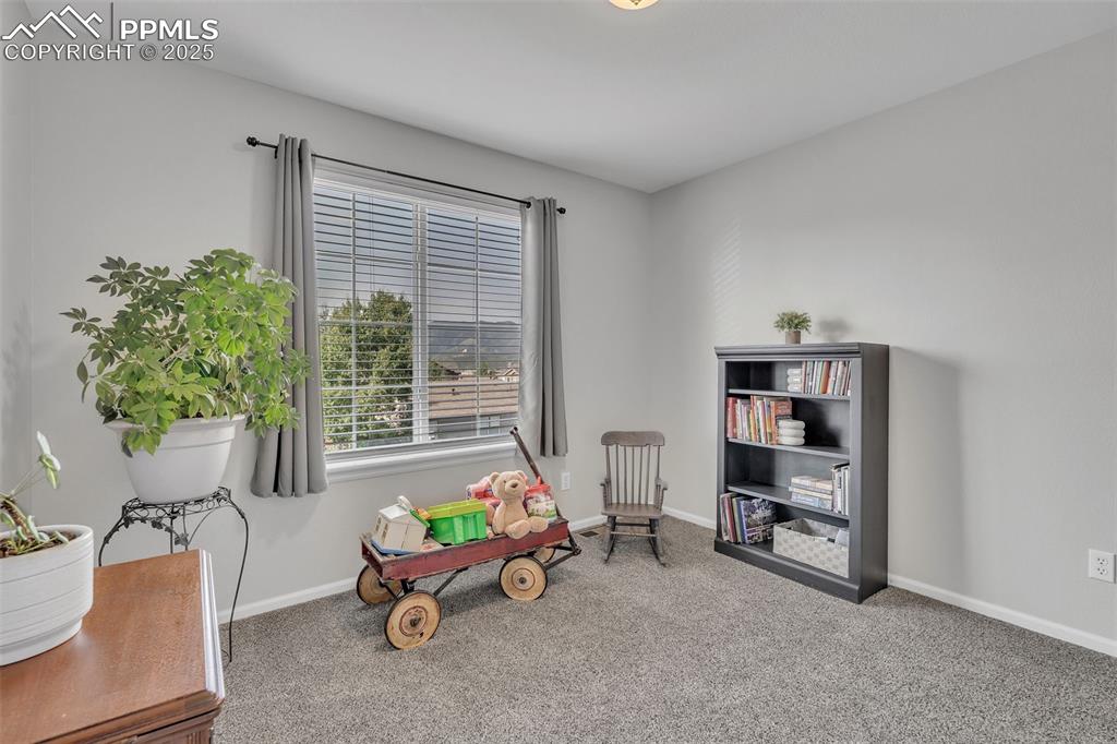 Image 22 of 50: Living area featuring light carpet and baseboards