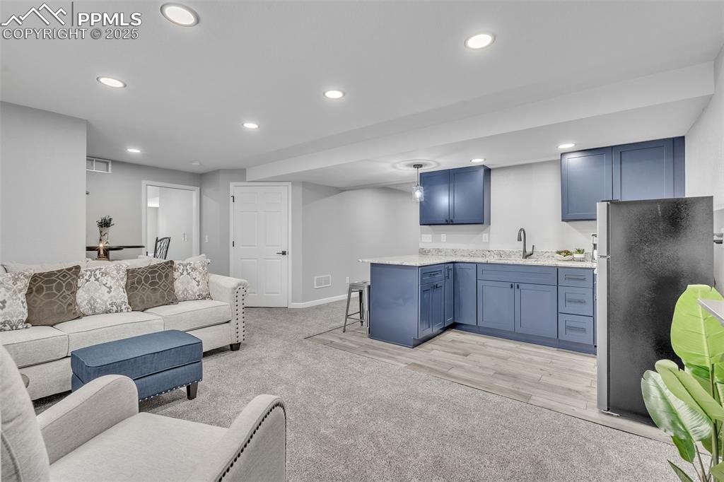 Image 33 of 50: Living area featuring light colored carpet and recessed lighting