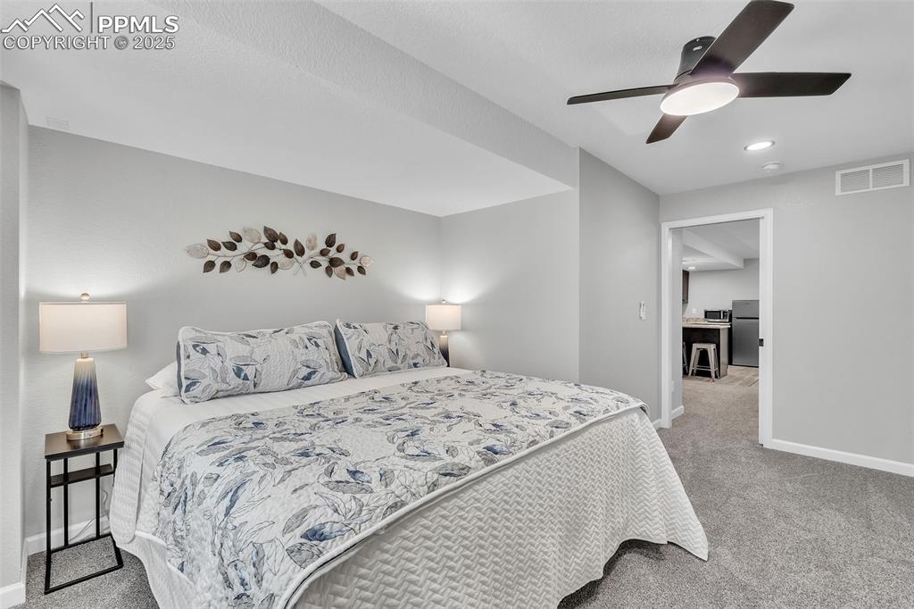 Image 36 of 50: Bedroom featuring light carpet, a ceiling fan, recessed lighting, and stain