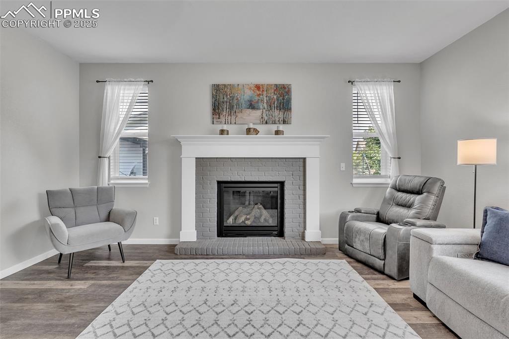 Image 4 of 50: Living room with wood finished floors and a fireplace