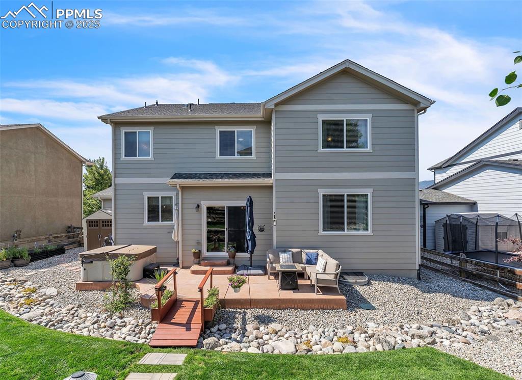 Image 40 of 50: Rear view of property with an outdoor hangout area, a hot tub, a shed, a de