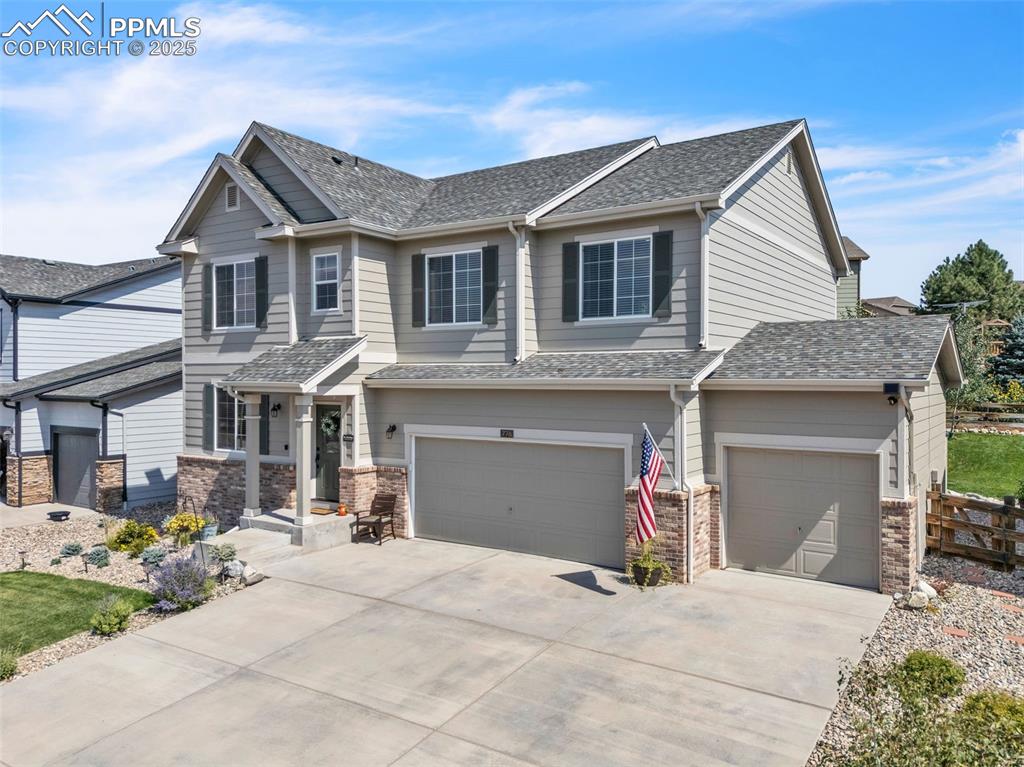 Image 43 of 50: Craftsman inspired home with a garage, driveway, and roof with shingles
