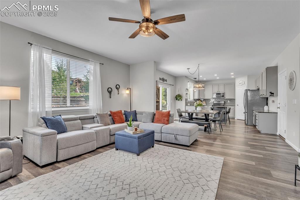 Image 6 of 50: Living room featuring light wood-style floors, a ceiling fan, recessed ligh