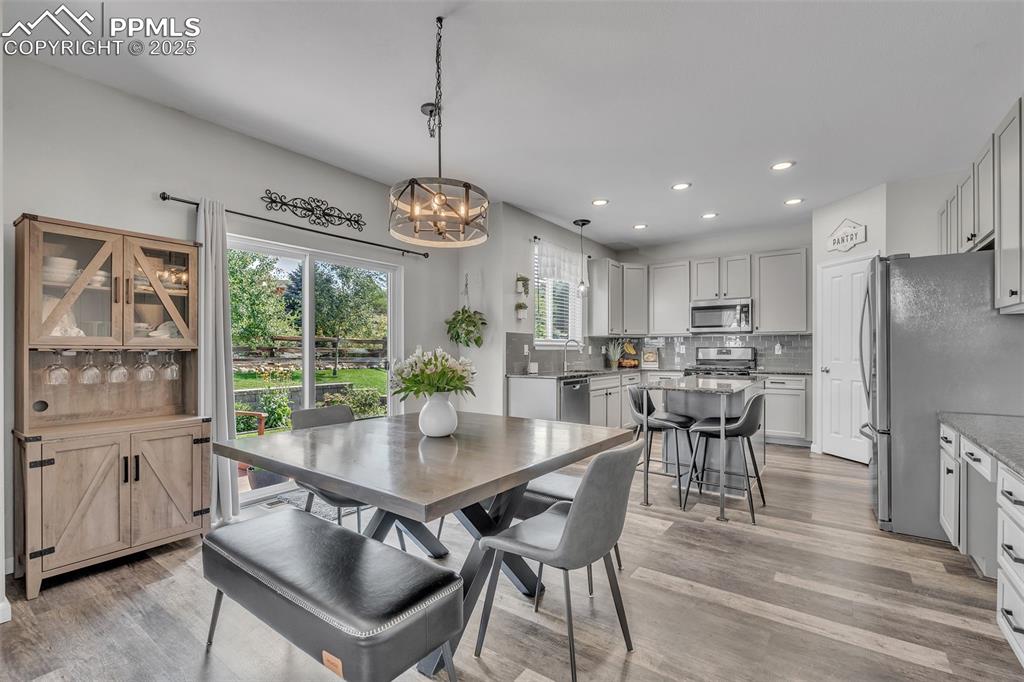 Image 7 of 50: Dining space featuring light wood-style floors, recessed lighting, and a ch