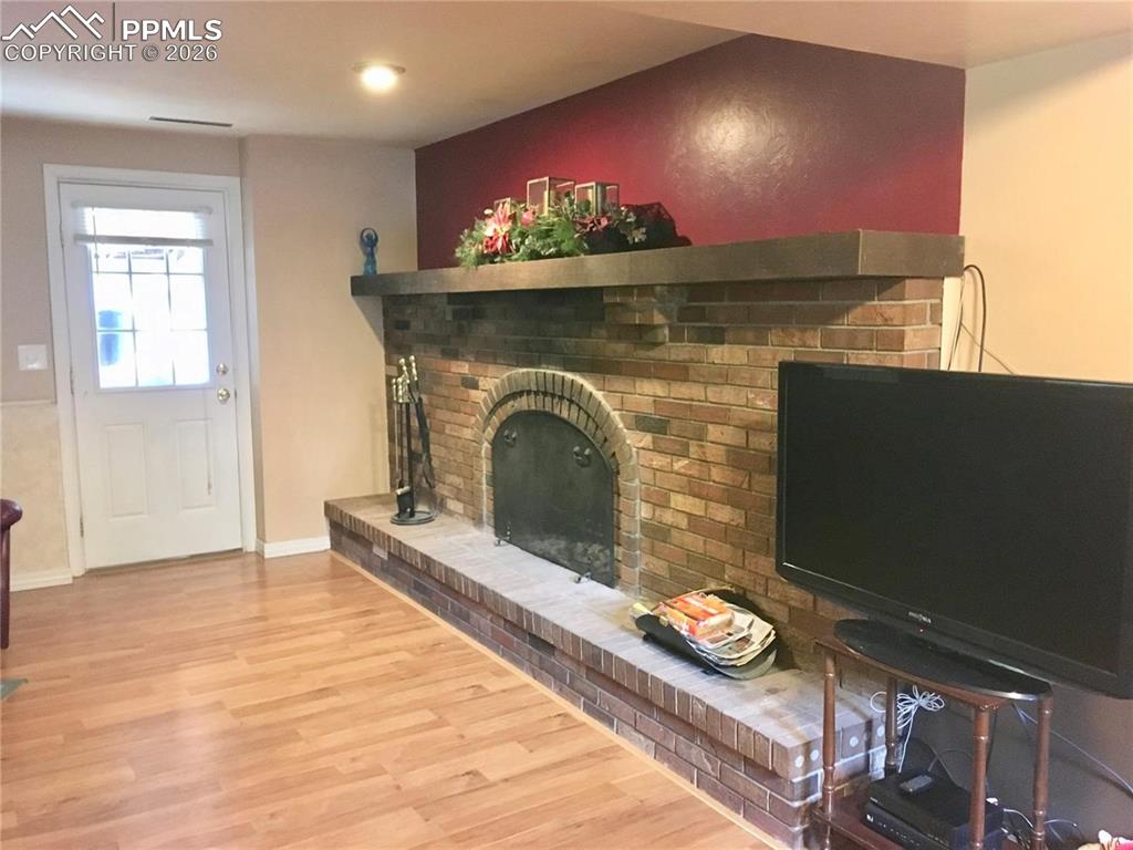 Image 13 of 33: Beautiful wood-burning fireplace in lower level family room.