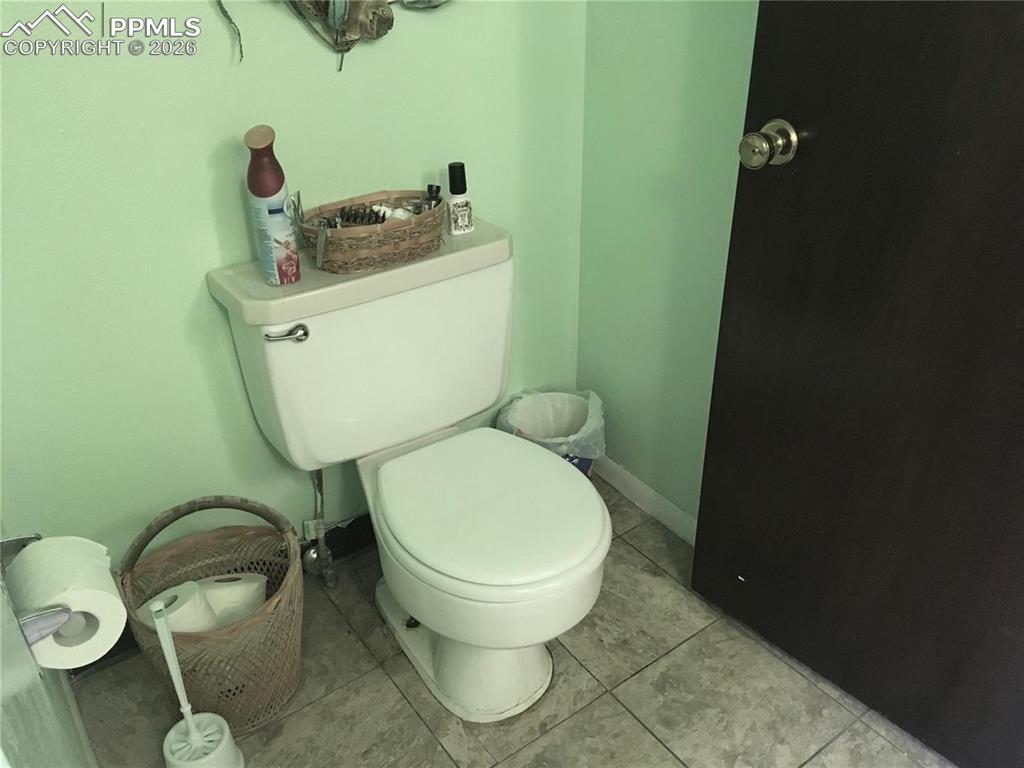 Image 15 of 33: Lower level office area adjacent to family room. Add a wall and door for a