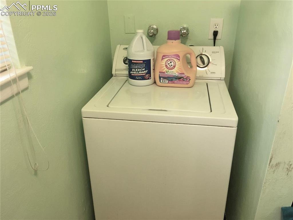 Image 17 of 33: Lower level family room with brick wood-burning fireplace offers access to