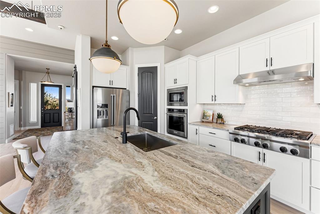 Image 16 of 50: New Fantasy Brown marble countertops and the back wall has a gas cooktop wi