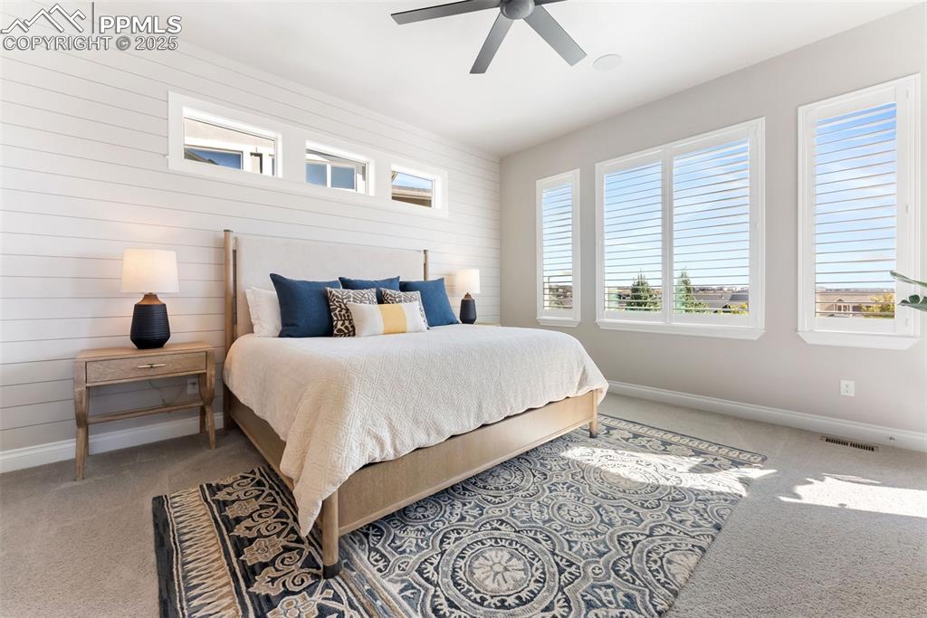 Image 19 of 50: The primary bedroom offers great space and large windows with shutters to l