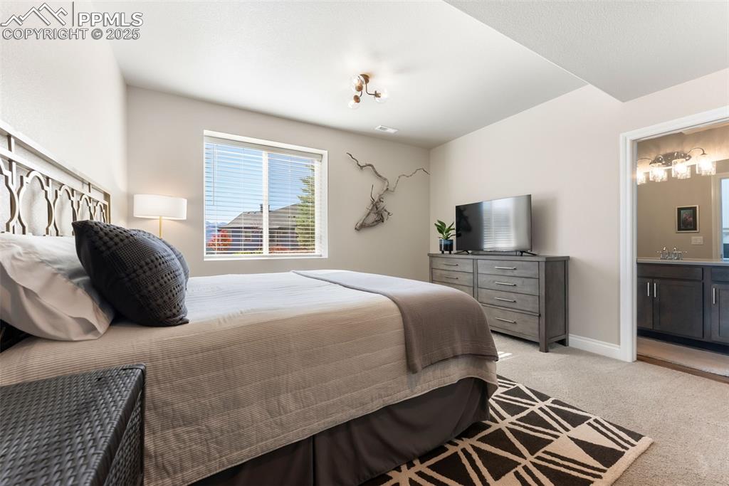Image 37 of 50: Third bedroom on the basement level and adjoining bathroom