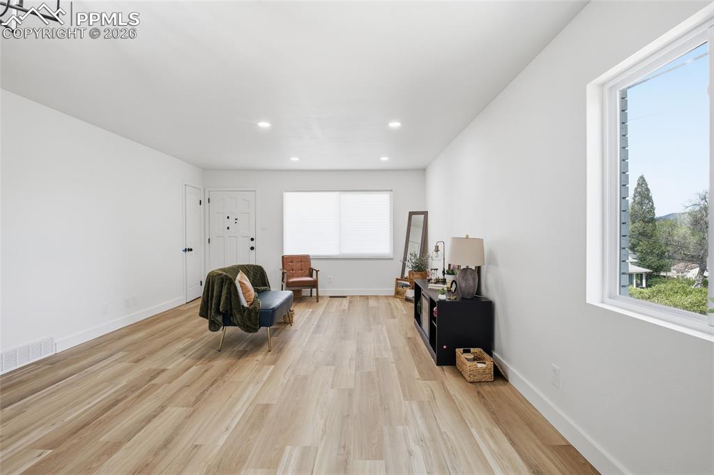Image 19 of 44: The property features light wood flooring, white walls, and a window provid