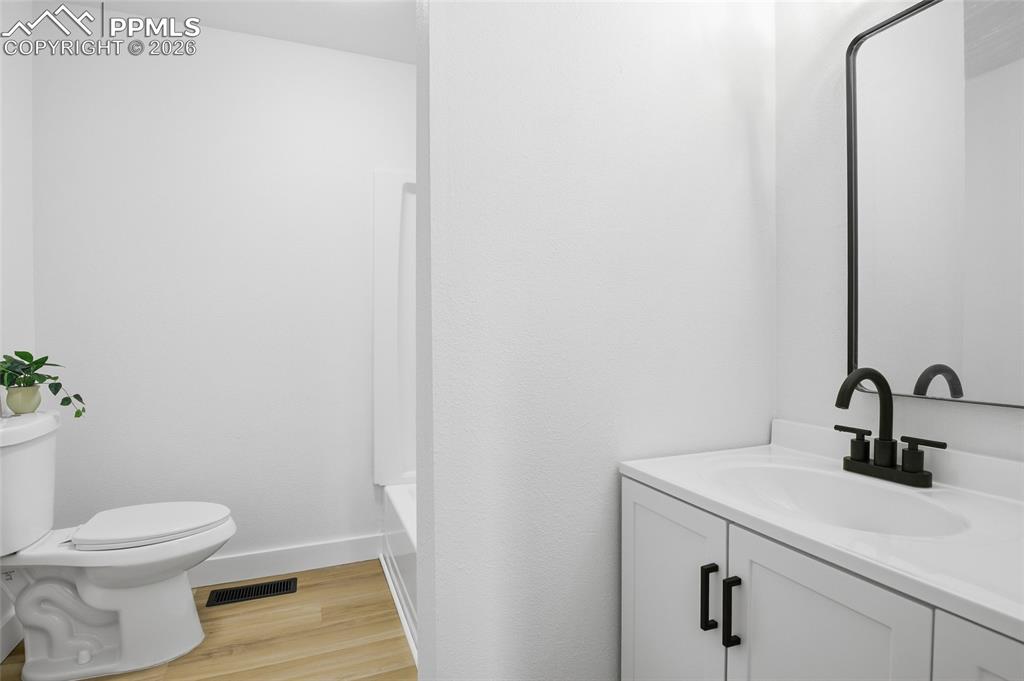 Image 28 of 44: Bathroom featuring a white vanity with a single basin sink, matte black fau