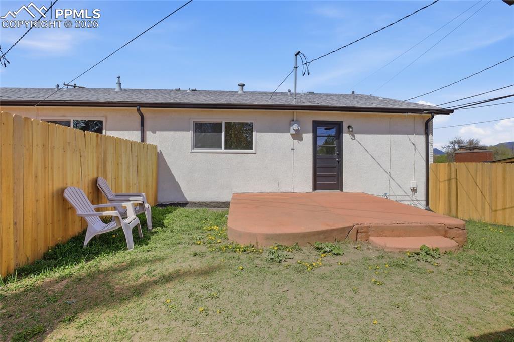 Image 31 of 44: The property features a fenced backyard with a concrete patio, a private en