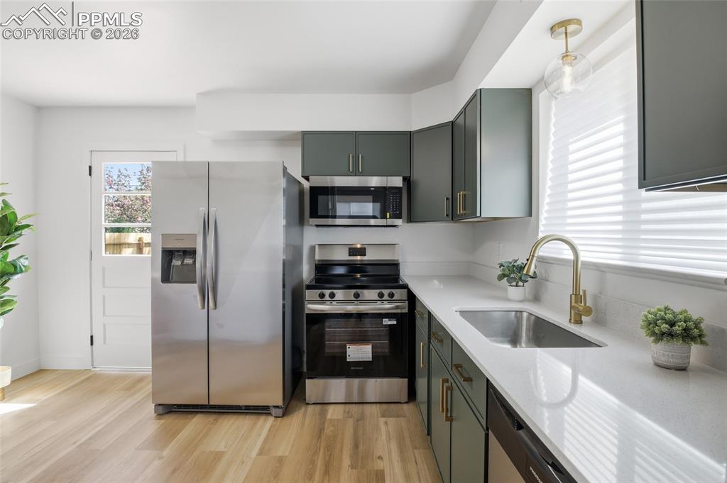 Image 4 of 44: The kitchen features stainless steel appliances, including a side-by-side r