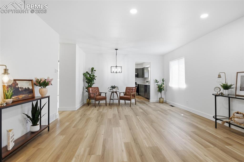 Image 5 of 44: This expansive living space features light-toned hardwood flooring, recesse