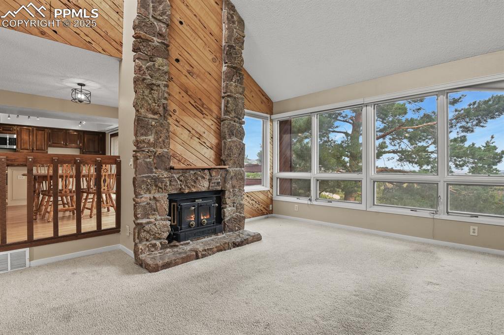 Image 6 of 35: Beautiful stone and wood fireplace with electric insert to keep you warm on