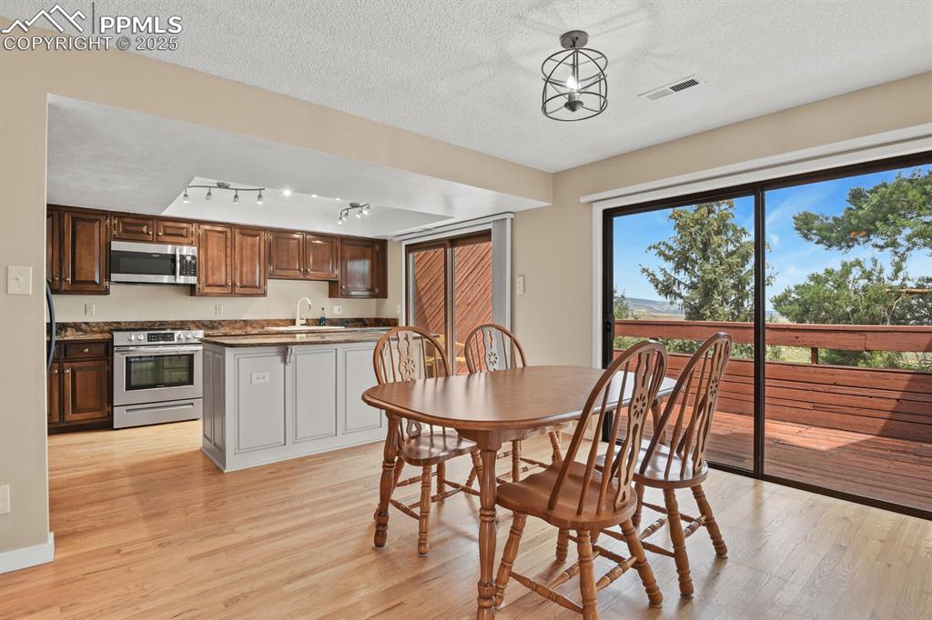 Image 8 of 35: Open dining and kitchen with beautiful hardwood floors and two slider doors