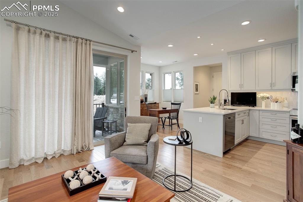 Image 14 of 28: Kitchen featuring a peninsula, stainless steel dishwasher, a sink, vaulted 