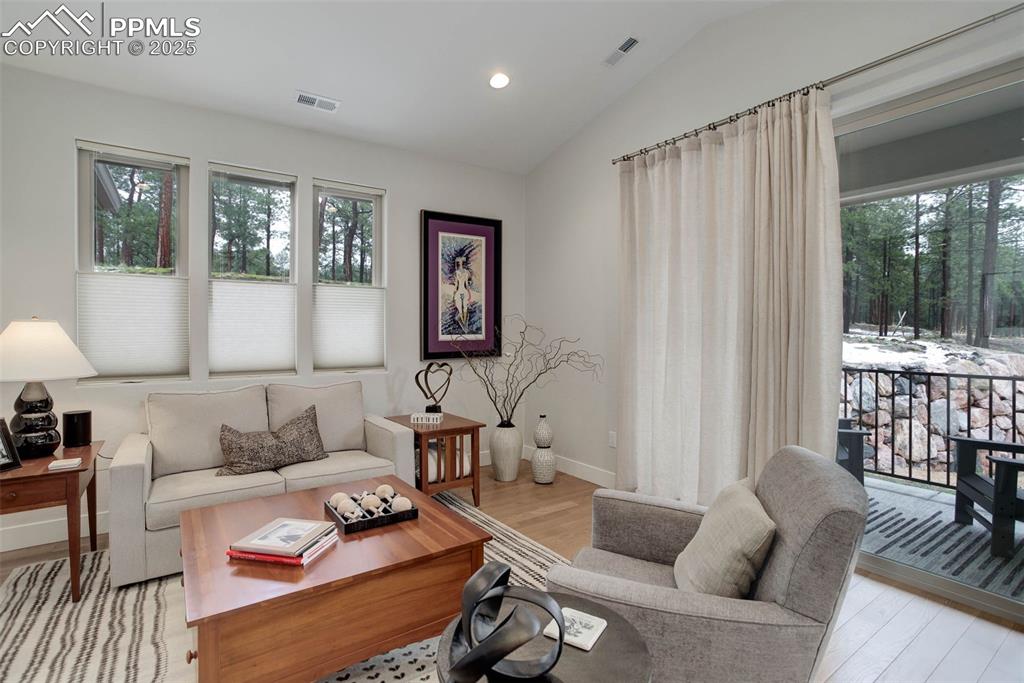 Image 15 of 28: Living area featuring light wood-type flooring, lofted ceiling, baseboards,