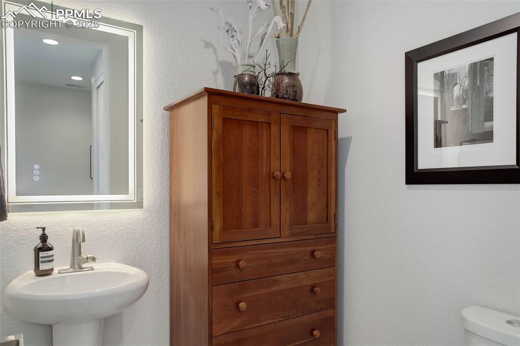 Image 17 of 28: Bathroom with a sink, toilet, and recessed lighting