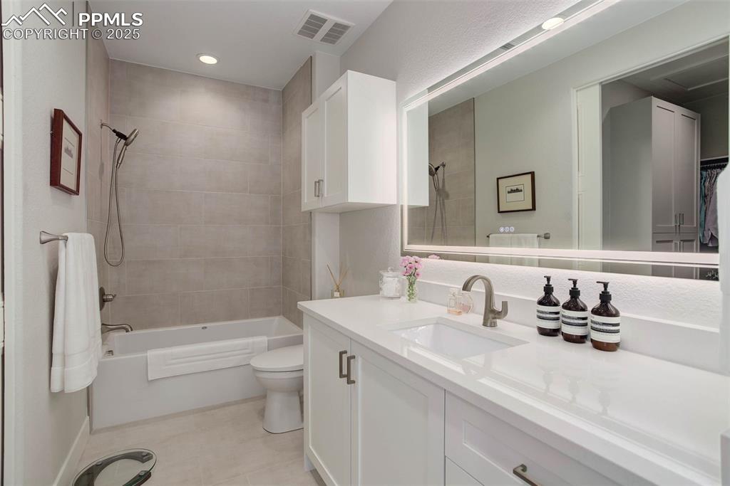 Image 22 of 28: Full bathroom featuring toilet, bathing tub / shower combination, vanity, a