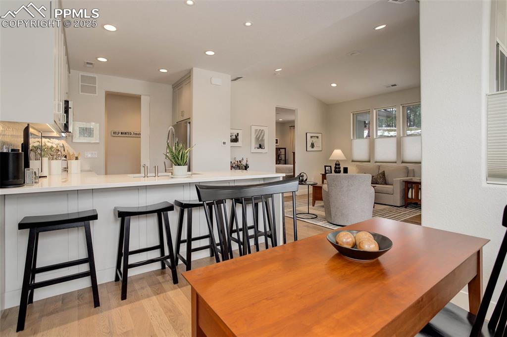 Image 8 of 28: Dining space with light wood-style floors, recessed lighting, and lofted ce